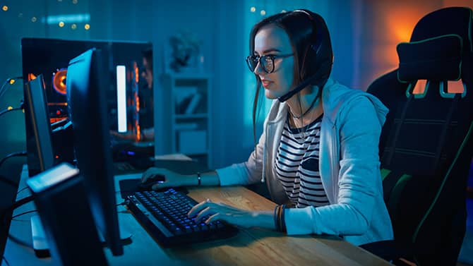Çevrimiçi oyun oynayan bir kadın. Oyun oynamak eğlencelidir ancak çevrimiçi oyunların güvenliğinin farkında olmak önemlidir.